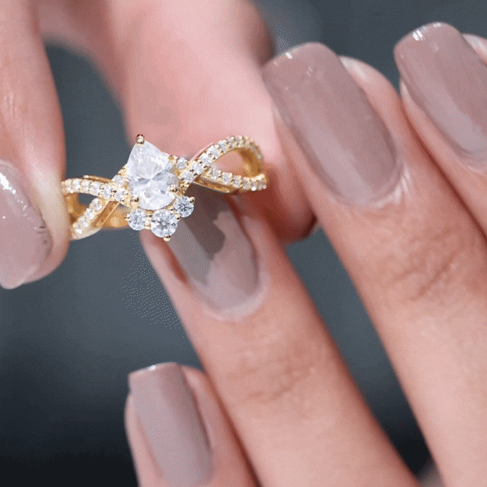 Yellow gold designer pear-shaped moissanite crossover engagement ring by Rosec Jewels, featuring a unique intertwined band design.