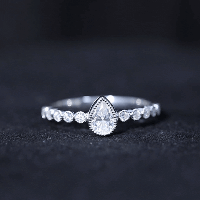 Beaded bezel set moissanite pear-shaped engagement ring by Rosec Jewels featuring yellow gold and intricate beaded detailing.