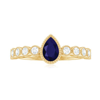 Pear cut 0.5 carat blue sapphire engagement ring with diamonds, featuring a rose gold band from Rosec Jewels.
