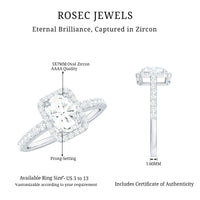 Oval cut zircon halo engagement ring with side stones from Rosec Jewels, featuring a sparkling center and detailed band design.