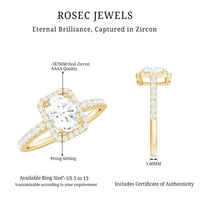 Oval cut zircon halo engagement ring with side stones from Rosec Jewels, featuring a sparkling center and detailed metal band.