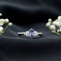 Vintage-style marquise tanzanite promise ring with diamond trio accents from Rosec Jewels, showcasing intricate design and sparkling gemstones.
