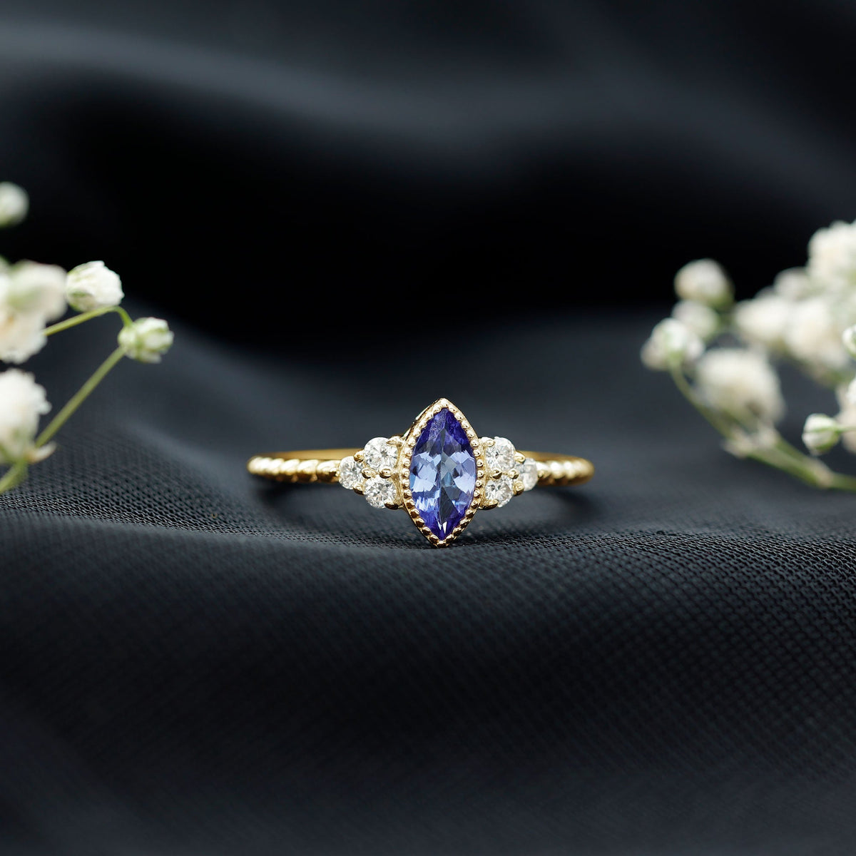 Vintage style Marquise Tanzanite promise ring with diamond trio, featuring intricate gold band and elegant design by Rosec Jewels.