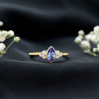 Vintage style Marquise Tanzanite promise ring with diamond trio, featuring intricate gold band and elegant design by Rosec Jewels.