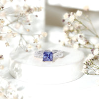 Certified 1.5 carat lab-grown blue sapphire princess cut engagement ring with diamonds, featuring a rose gold band.