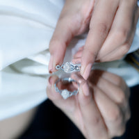 Round moissanite crossover halo engagement ring from Rosec Jewels with intricate design and sparkling stones.