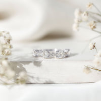 Round moissanite half eternity wedding band by Rosec Jewels featuring sparkling stones set in a sleek gold ring.