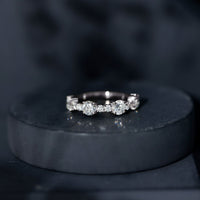 Round moissanite half eternity wedding band from Rosec Jewels featuring sparkling stones set in a sleek ring design