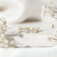 Round moissanite half eternity wedding band by Rosec Jewels, showcasing sparkling stones set in a sleek, elegant ring design.