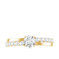 Round cut moissanite engagement ring with side stones, featuring a polished band and sparkling gemstone accents.