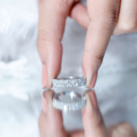 Double row moissanite eternity wedding band by Rosec Jewels featuring sparkling gemstones and a sleek, elegant ring design.