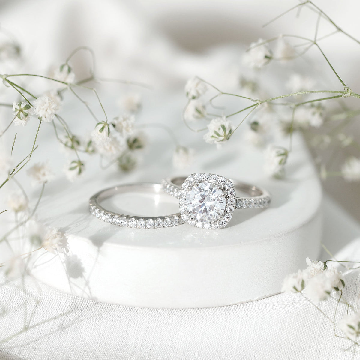 Silver cubic zirconia engagement ring with 2 carat center stone paired with matching wedding band, designed by Rosec Jewels.