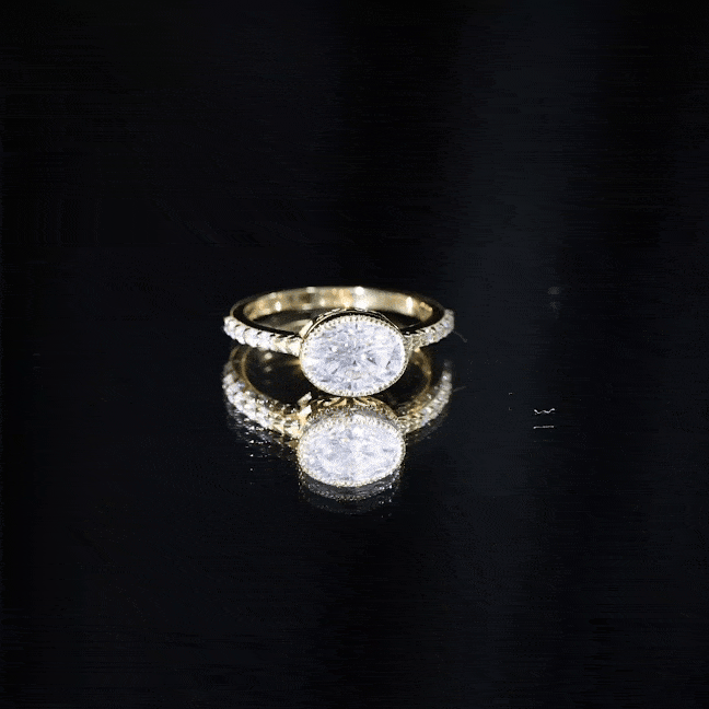 Oval lab-grown diamond solitaire engagement ring in a bezel setting by Rosec Jewels, featuring a yellow band and elegant design.