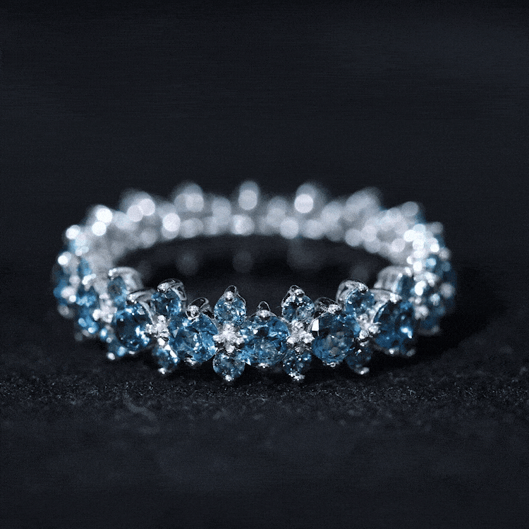 Rosec Jewels London Blue Topaz Cluster Eternity Band Ring showcasing a sparkling blue topaz cluster on a silver band