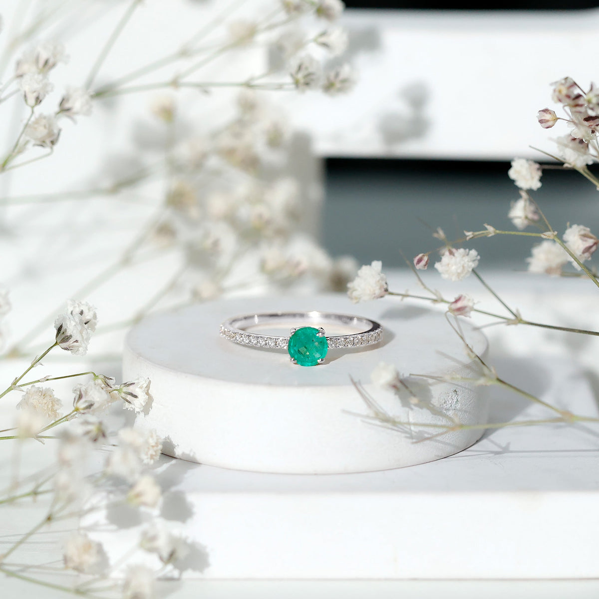 Natural emerald promise ring with diamond side stones, featuring a gold band and intricate design by Rosec Jewels.