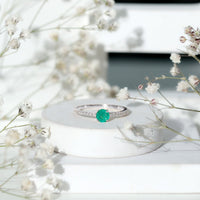 Natural emerald promise ring with diamond side stones, featuring a gold band and intricate design by Rosec Jewels.