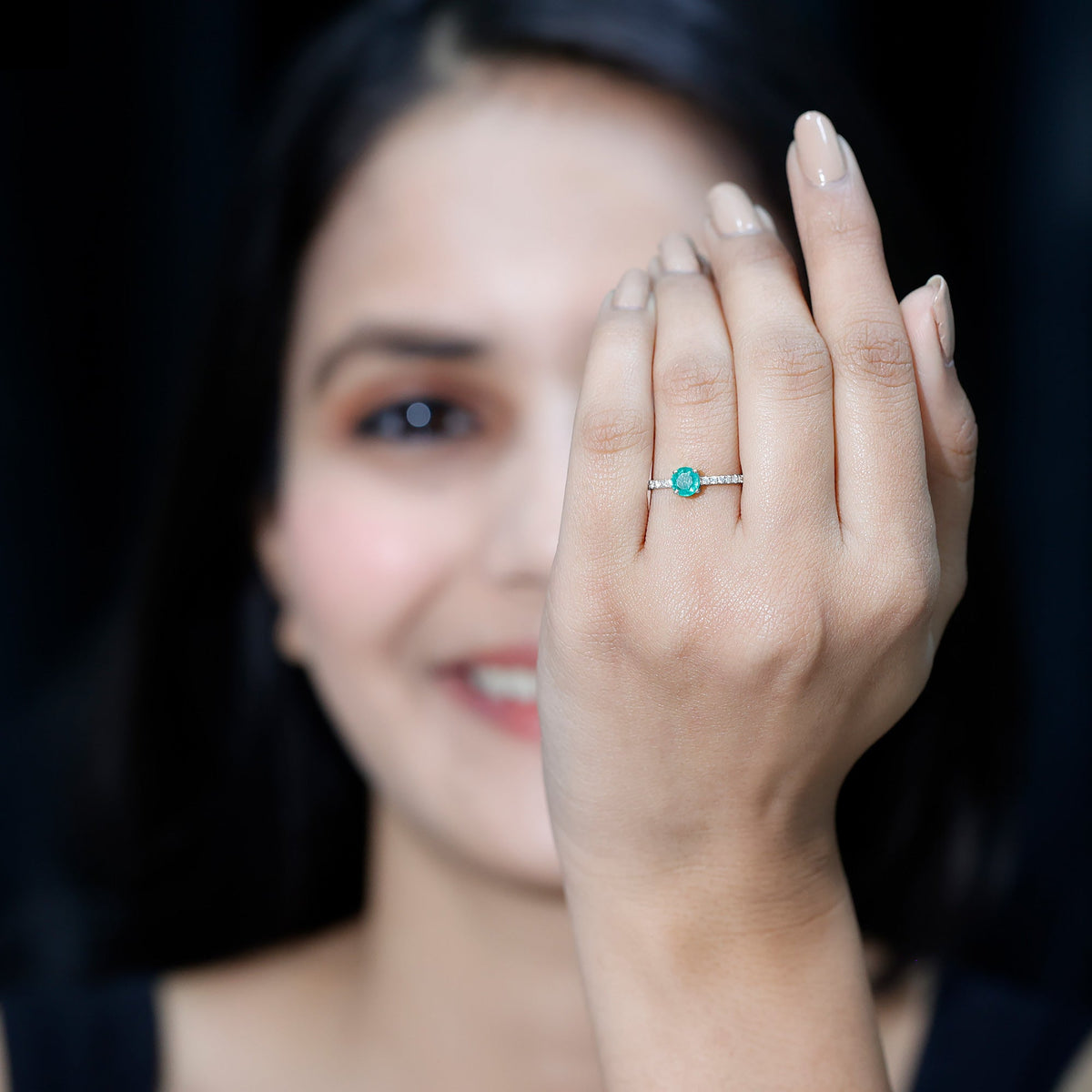 Natural emerald promise ring with diamond side stones by Rosec Jewels, featuring a central green emerald and sparkling accent diamonds.