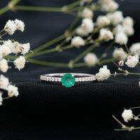 Natural emerald promise ring by Rosec Jewels featuring diamond side stones on a sleek gold band.