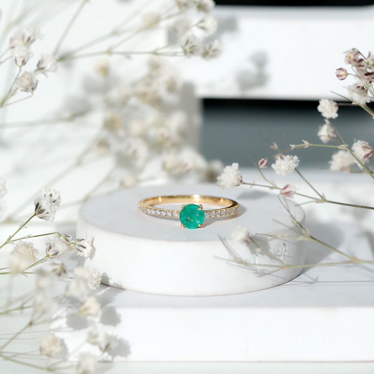 Natural emerald promise ring with diamond side stones from Rosec Jewels, featuring a central emerald gemstone and sparkling accents.