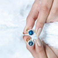 Round London Blue Topaz engagement ring with diamond halo, 2 carats, set in a classic design by Rosec Jewels.