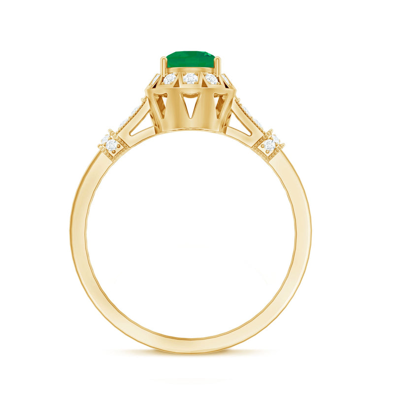 Vintage-inspired emerald engagement ring with diamond accents from Rosec Jewels, showcasing a detailed gold band and sparkling gemstones.
