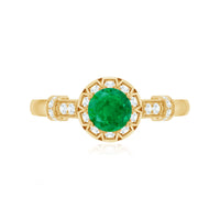 Vintage-inspired emerald engagement ring with diamond accents by Rosec Jewels, featuring intricate metalwork and a vibrant emerald gemstone.