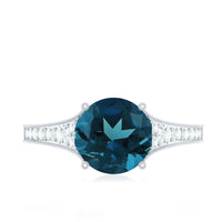 Rosec Jewels London Blue Topaz and diamond engagement ring with a silver band and intricate detailing, showcasing a sparkling blue topaz.