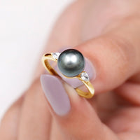 Round Tahitian pearl solitaire engagement ring with moissanite by Rosec Jewels, showcasing the elegant pearl and sparkling gemstone setting.