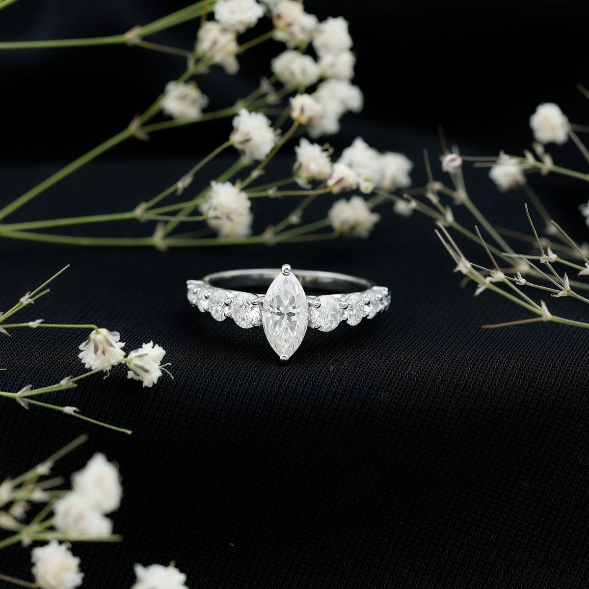 Marquise cut moissanite engagement ring with side stones from Rosec Jewels, showcasing sparkling center stone and elegant band.
