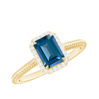 Emerald cut blue topaz engagement ring with diamond halo by Rosec Jewels, featuring a silver band and intricate detailing.