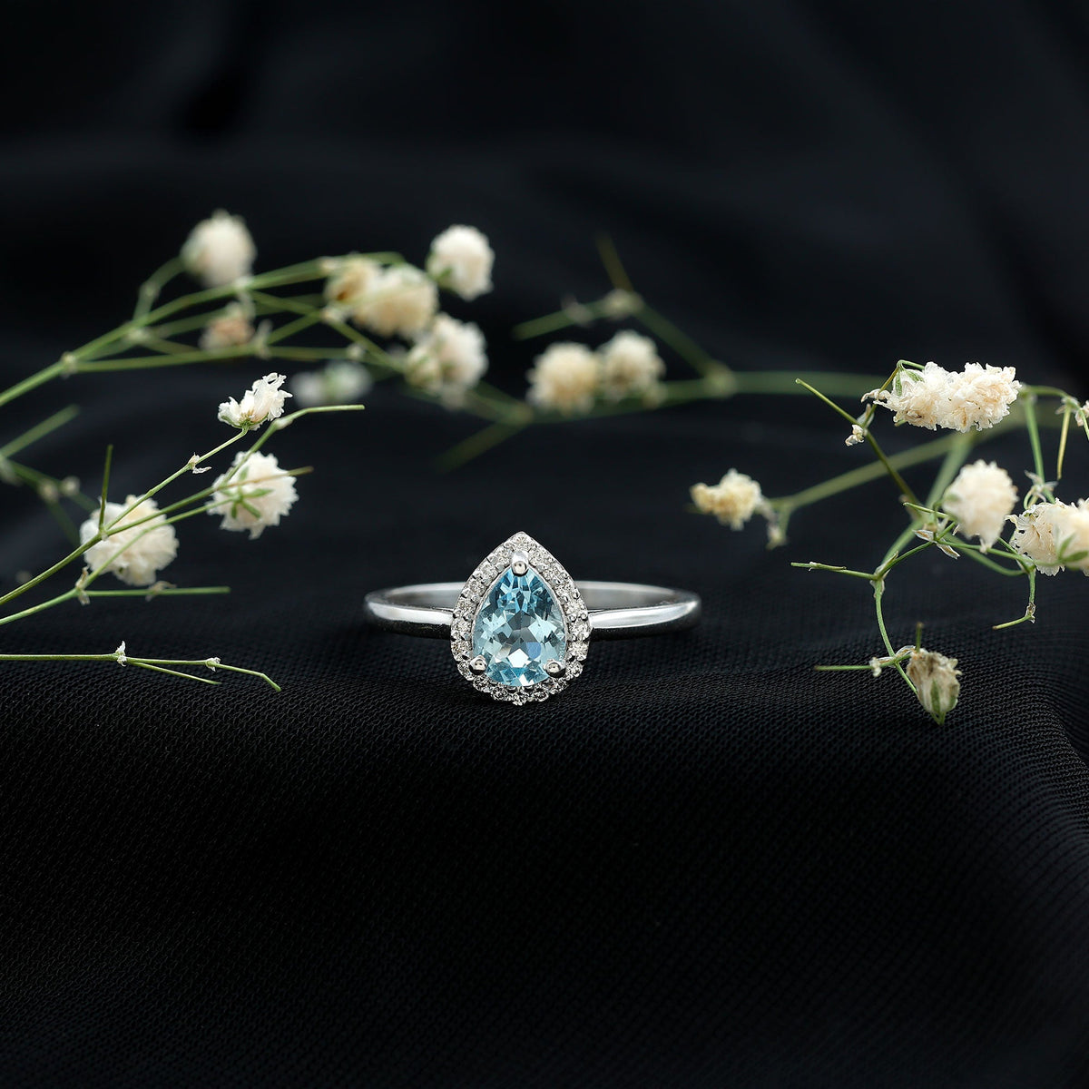 Pear-shaped 1 carat aquamarine engagement ring with diamond halo by Rosec Jewels, featuring a sterling silver band.