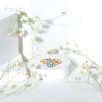 Pear-shaped 1-carat aquamarine engagement ring with diamond halo, shown from a side view, featuring intricate band details.