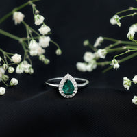 Elegant real emerald teardrop engagement ring with diamond halo from Rosec Jewels, showcasing a shimmering emerald center and sparkling diamonds.