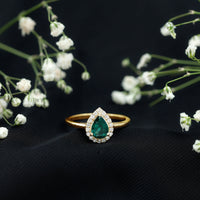 Real emerald teardrop engagement ring with diamond halo from Rosec Jewels, showcasing intricate design and sparkling gemstones.