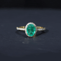 Genuine oval emerald engagement ring with diamond halo, 6x8mm size, featuring yellow gold band and intricate setting.