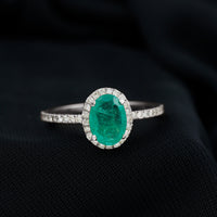 Oval emerald engagement ring with diamond halo in 6x8mm size from Rosec Jewels, showcasing a sparkling gemstone and intricate design.