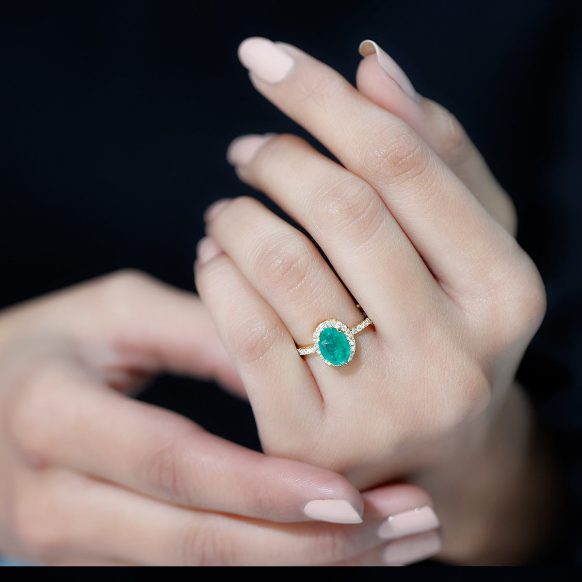 Genuine 6x8mm oval emerald engagement ring with diamond halo by Rosec Jewels, featuring a gold band and intricate detailing.