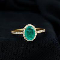 Genuine 6x8mm oval emerald engagement ring with diamond halo by Rosec Jewels, showcasing the detailed ring design and sparkling stones.