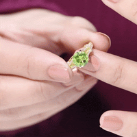 Peridot solitaire engagement ring with moissanite accents in a split shank design by Rosec Jewels.