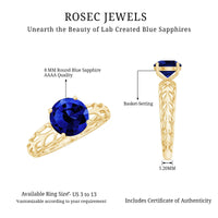 Lab-created blue sapphire solitaire ring with intricate filigree shank from Rosec Jewels, showcasing a sparkling blue gemstone and detailed design.