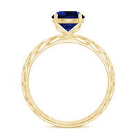 Lab-created blue sapphire solitaire ring with filigree shank by Rosec Jewels, showcasing a sparkling blue gemstone and intricate metalwork.