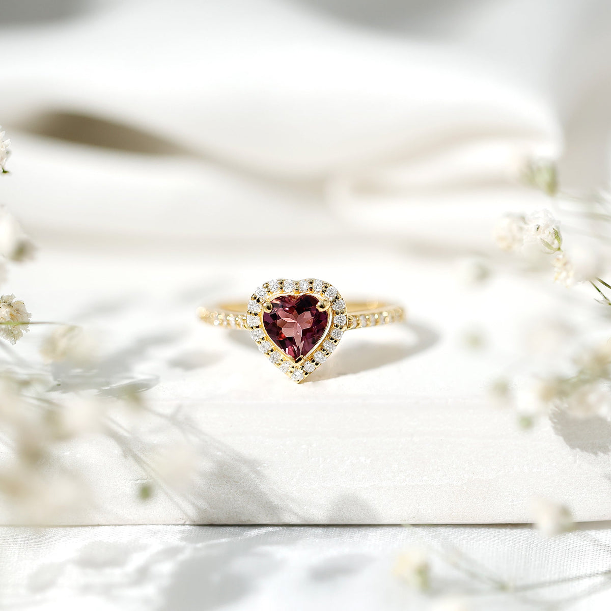 Pink heart-shaped tourmaline engagement ring with diamond halo from Rosec Jewels, showcasing the detailed gemstone and elegant design.