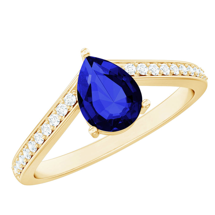 Pear-shaped blue sapphire lab-grown engagement ring with diamond accents, featuring a chevron design by Rosec Jewels.
