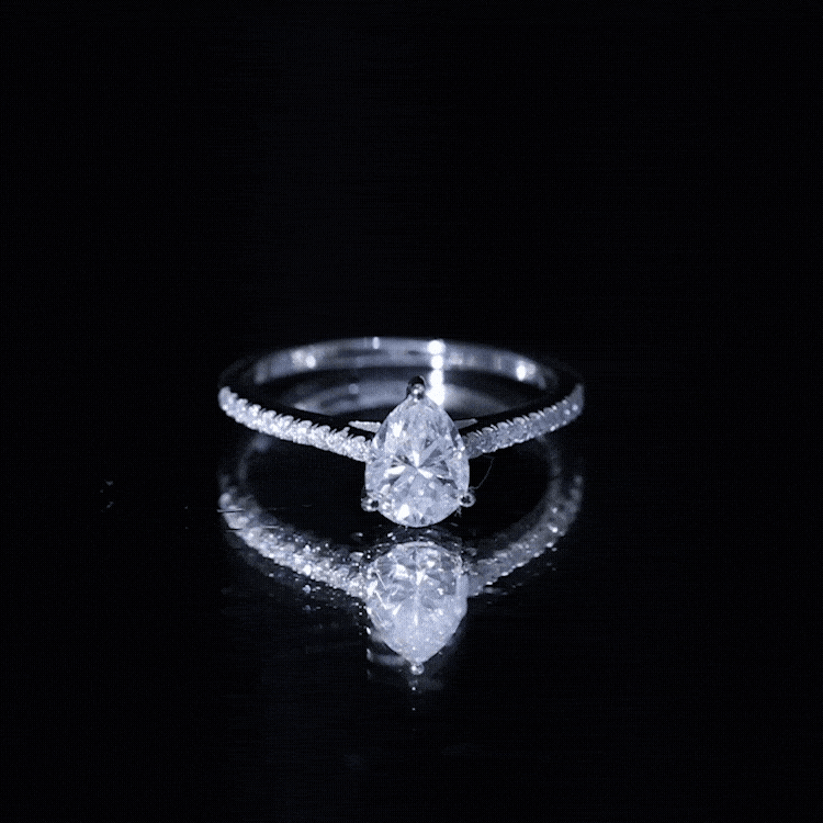 Pear-shaped moissanite engagement ring with side stones from Rosec Jewels, showcasing a sparkling central gemstone and elegant design.