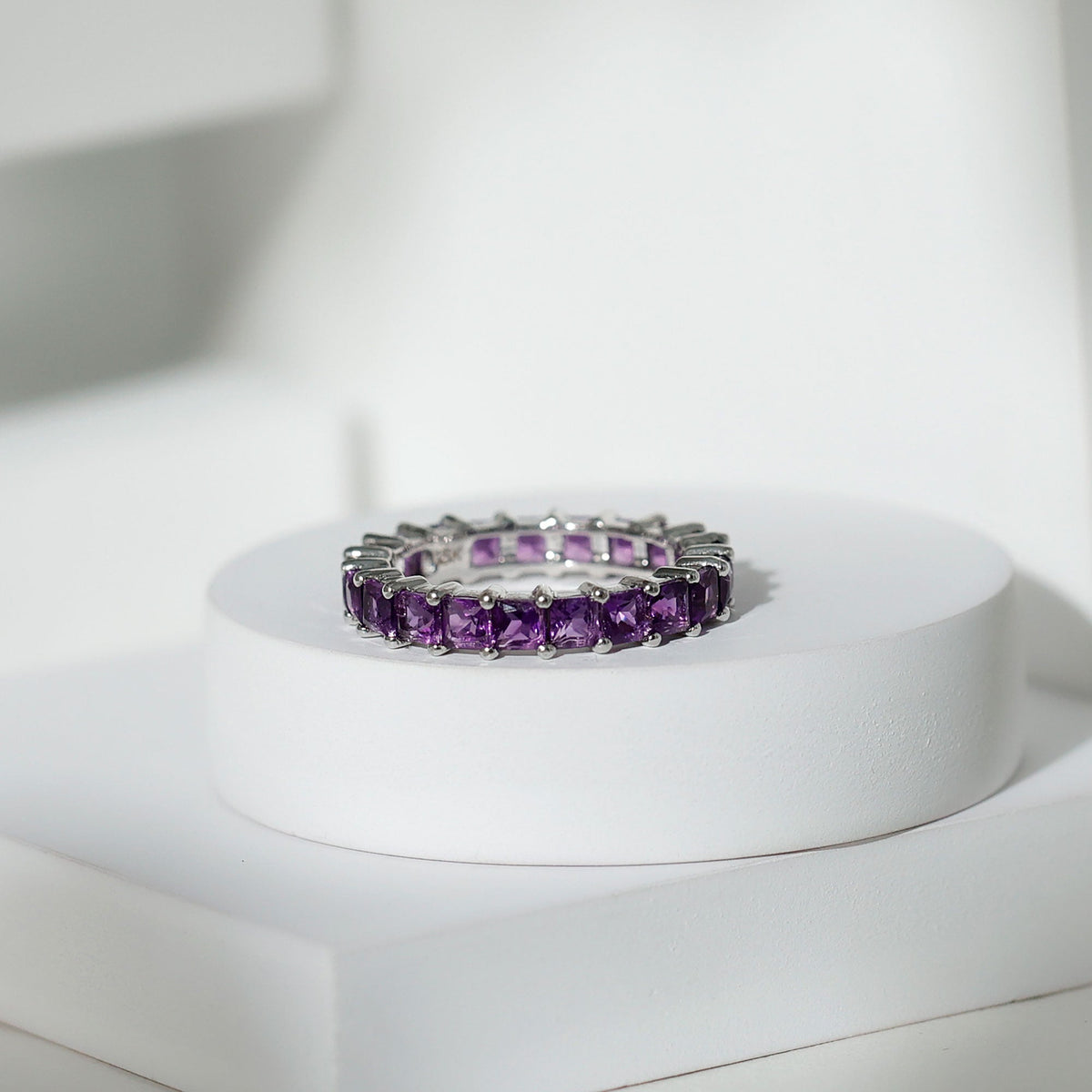 Rosec Jewels princess cut amethyst full eternity band ring showcasing alternating purple gemstones and sleek silver band.