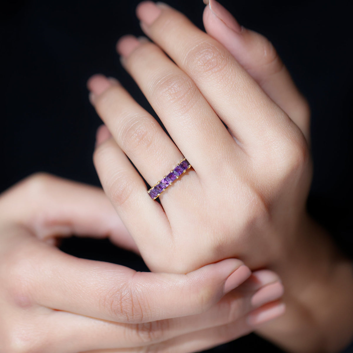 Rosec Jewels princess cut amethyst full eternity band ring with alternating gemstone settings on a gold band.