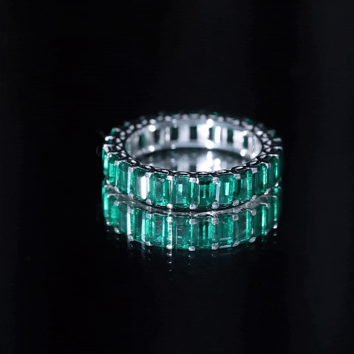 Emerald cut lab grown emerald eternity wedding band by Rosec Jewels featuring continuous green gemstones on a gold ring.