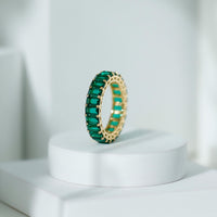 Emerald cut lab-grown emerald eternity wedding band by Rosec Jewels, showcasing a continuous row of sparkling emeralds on a sleek ring.