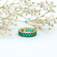 Emerald cut lab-grown emerald eternity wedding band by Rosec Jewels, featuring sparkling green gemstones in a continuous circle of rings.
