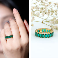 Emerald cut lab-grown emerald eternity wedding band by Rosec Jewels, showcasing a continuous row of sparkling emeralds on a sleek ring.